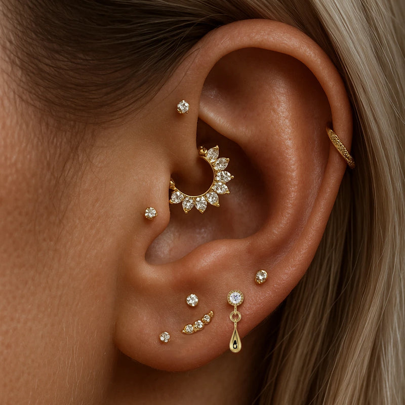 14K yellow gold dew drop labret stud worn in lobe piercing, styled with curated gold ear stack