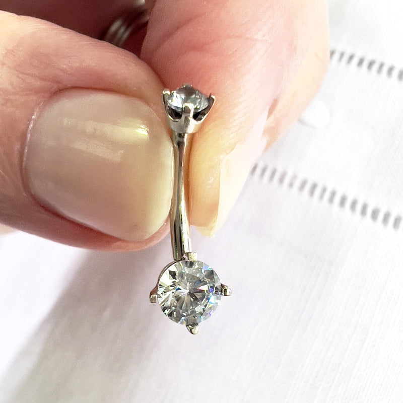 14k white gold CZ navel ring held between fingers for size reference, showing sparkling CZ gems