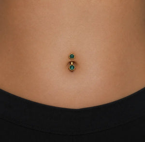 Model wearing the Reina London Blue Topaz Crown Curved Belly Ring in 14k gold