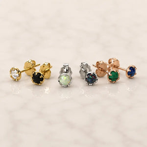 Grouping of Reina earrings with different colored gemstones on a light background