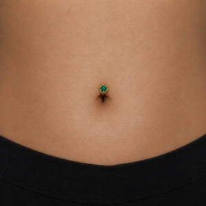 Model wearing the Reina Zambian Emerald Crown Floating Navel Ring in 14k gold