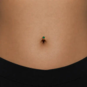 Model wearing the Reina Zambian Emerald Crown Floating Navel Ring in 14k gold