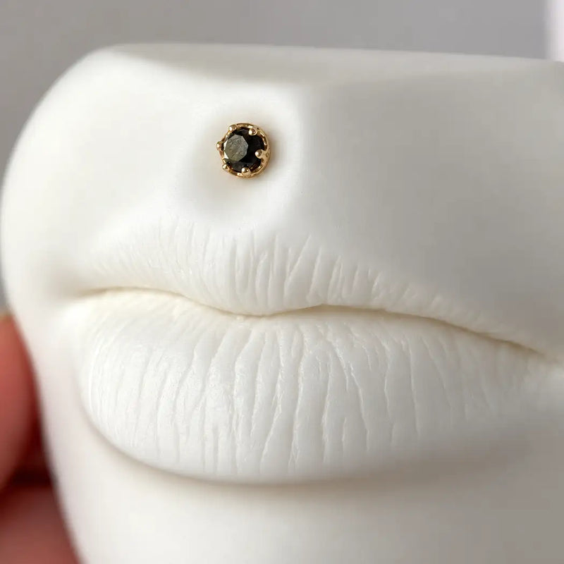 Reina rose cut black diamond flat back stud in 14k gold, worn above the lip on a lip model