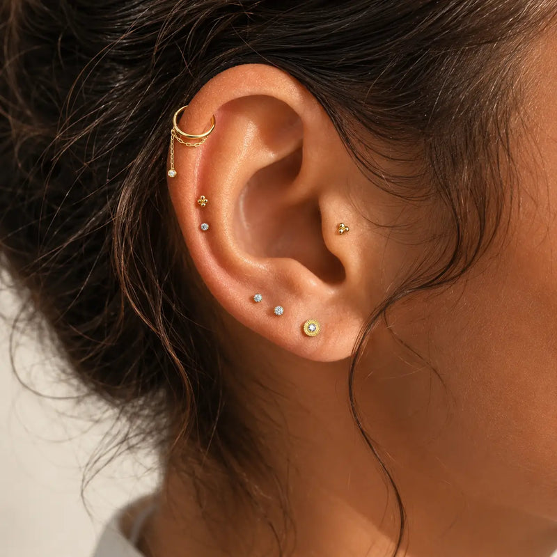 Ear model wearing the Shanti seam ring with other diamond studs and beaded gold flat back earrings.