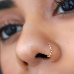 14K gold twisted nose hoop shown in pierced nostril, front-facing model view for fit reference