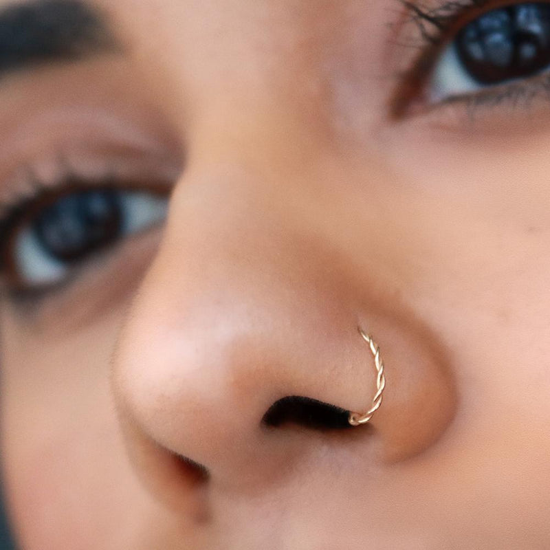 14K gold twisted nose hoop shown in pierced nostril, front-facing model view for fit reference