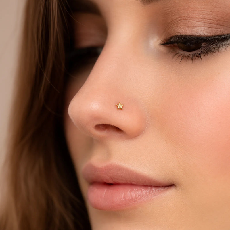 2mm solid 14k yellow gold star flat back stud worn in nostril piercing on model