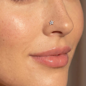 Model wearing the Starflower Diamond Nose Ring in 14k yellow gold in a nostril piercing