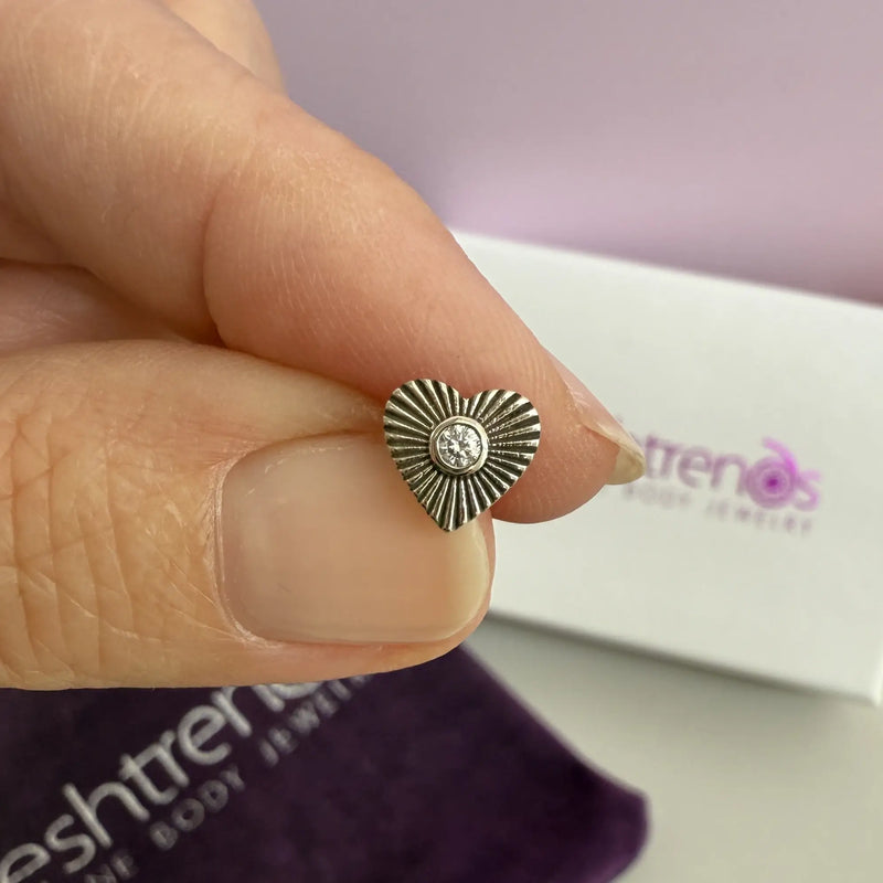 14k white gold sunburst heart diamond stud end pinched between fingers for scale, FreshTrends packaging behind