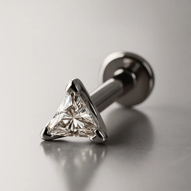 14k white gold triangle diamond flat back labret stud, angled lifestyle shot on grey background