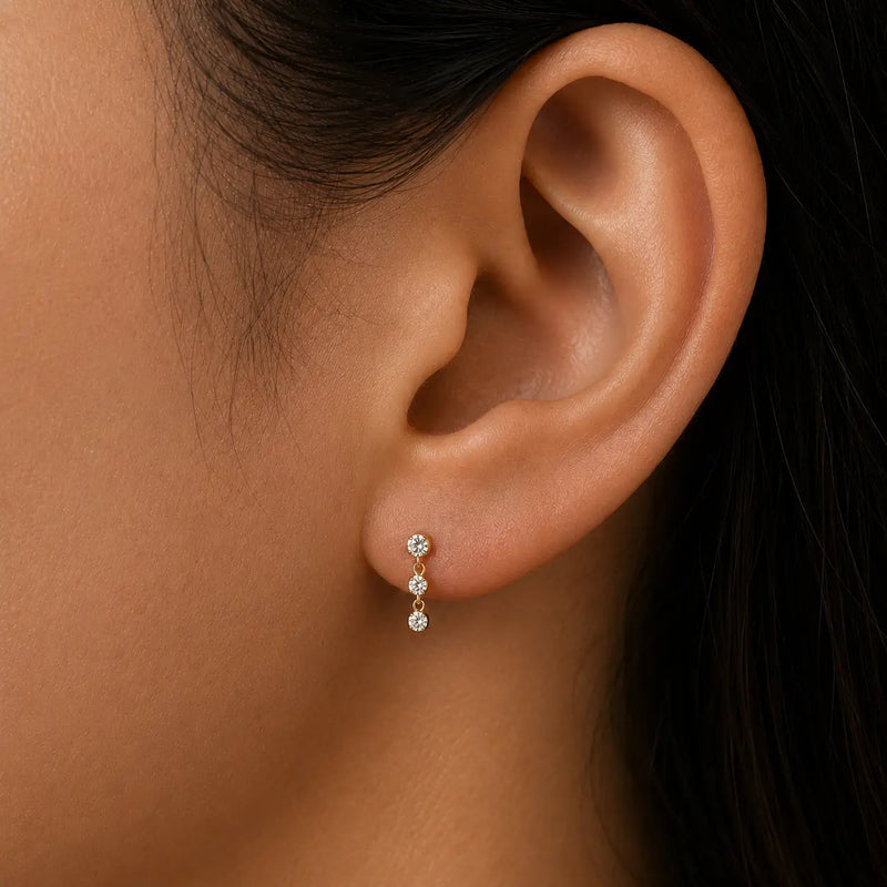 14K yellow gold trinity drop CZ flat-back stud shown in pierced earlobe, side profile for fit reference