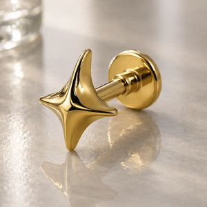 14k yellow gold sparkle flat back labret stud with four-point star charm, angled lifestyle shot