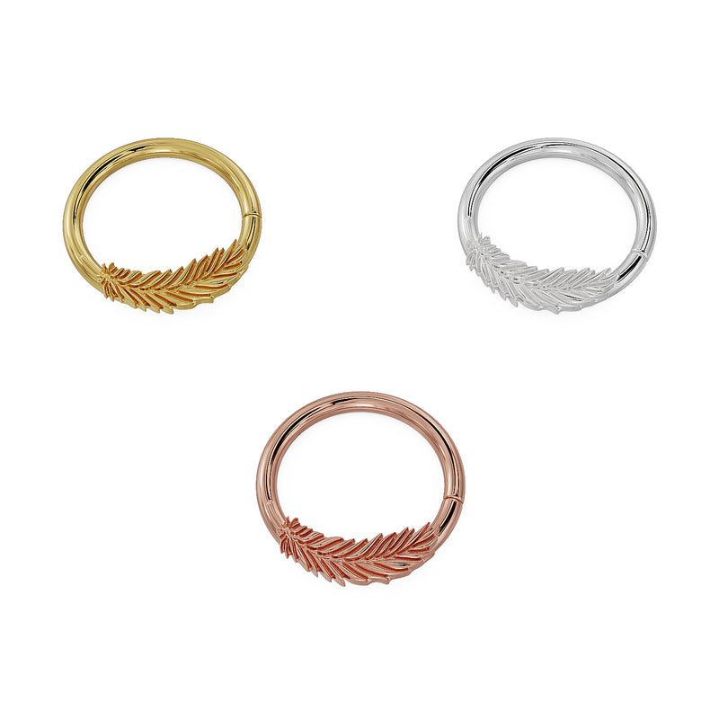 Angled flat-lay of feather seam rings in 14K yellow, white, and rose gold showing engraving detail