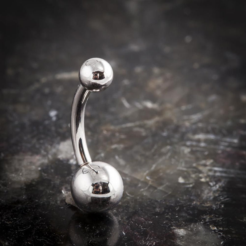 14k white gold double ball navel ring standing upright on dark reflective surface, front view
