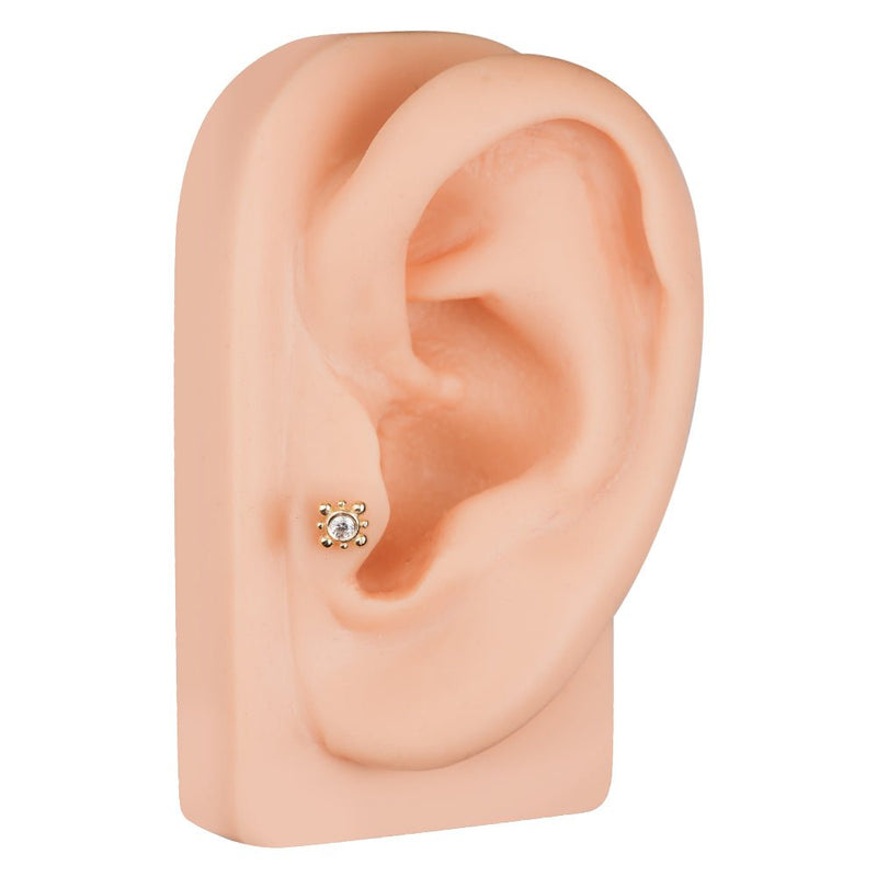 14k gold beaded bezel CZ cartilage stud on silicone ear model, lobe placement view