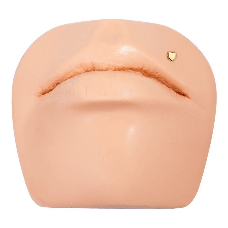 14K yellow gold heart flat back labret shown on lip piercing mannequin for placement reference