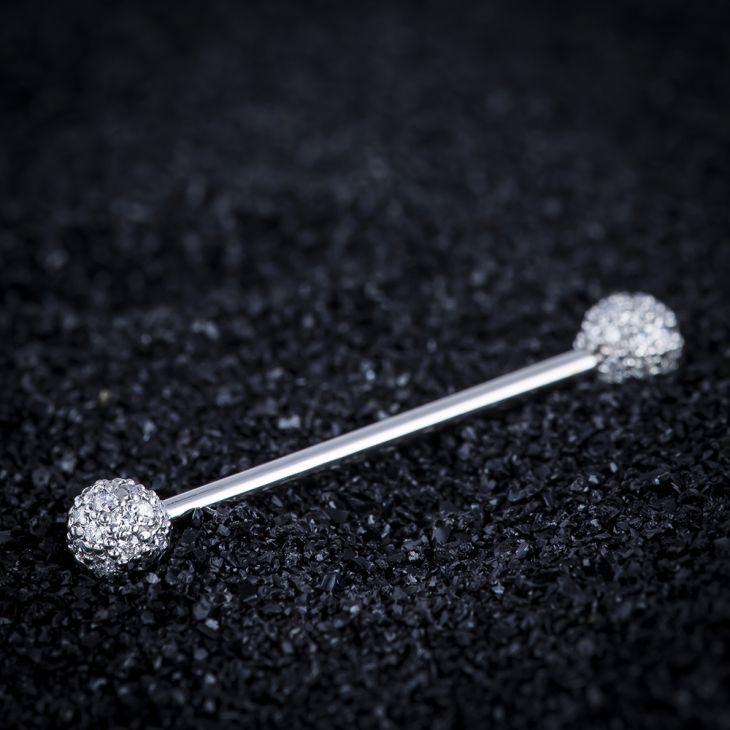 14K white gold diamond pavé straight barbell resting on dark textured surface, lifestyle shot