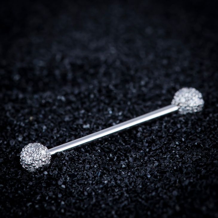 14k white gold diamond pavé straight barbell resting on dark textured surface, angled lifestyle shot