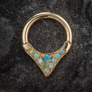 14K yellow gold opal clicker ring with V-shaped setting, displayed on dark stone surface