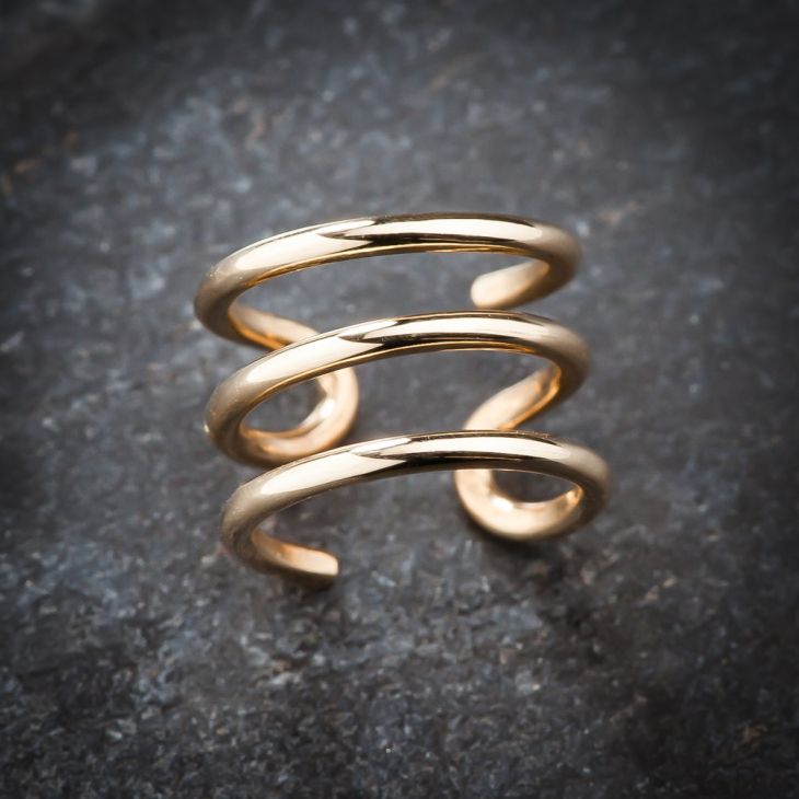 14k yellow gold three-band ear cuff on dark stone surface showing spiral wrap detail