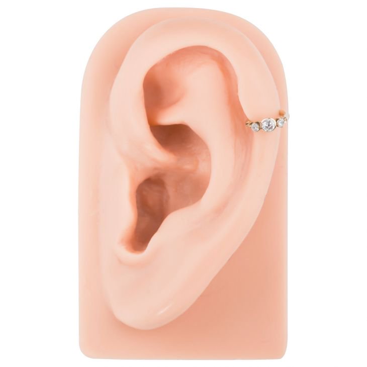 14k gold CZ clicker cartilage ring in helix piercing on silicone ear model, side profile view