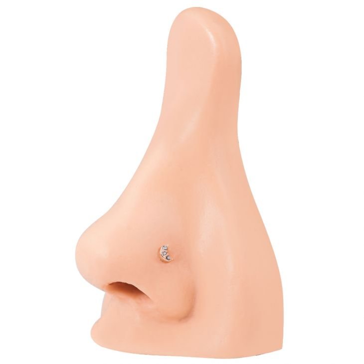 Rose gold diamond pave crescent moon stud worn in nostril piercing on silicone nose model