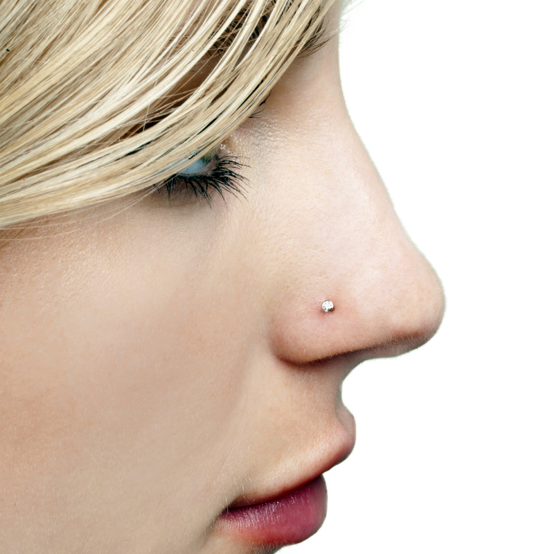 1.5mm diamond bezel nose stud shown on pierced nose, demonstrating subtle fit on model