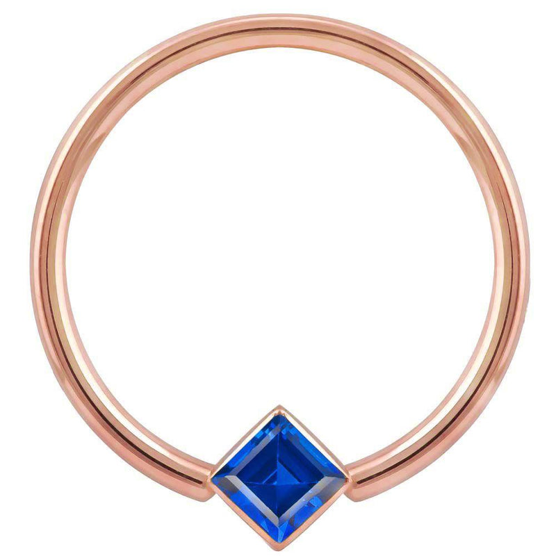 14k rose gold fixed bead ring with blue princess-cut CZ in corner bezel mount, front view
