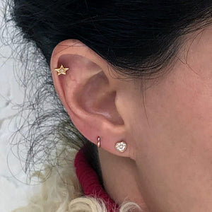 14k gold diamond star flat back stud worn in cartilage piercing, styled with other gold ear jewelry