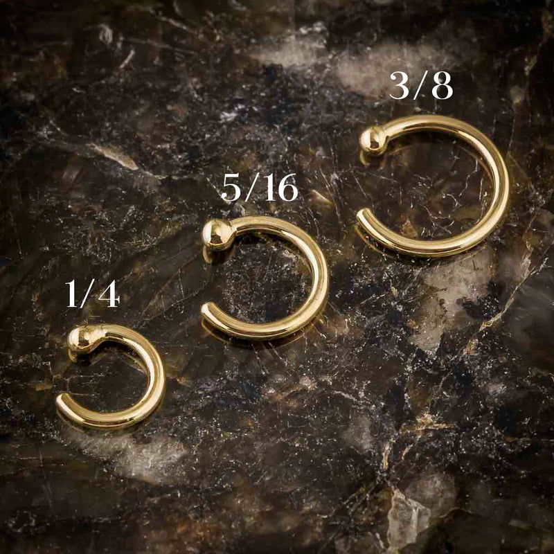 Three 14K gold nose hoops side by side showing 1/4, 5/16, and 3/8 inch diameter size comparison