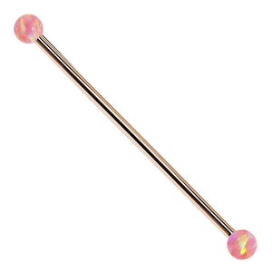 14k rose gold industrial barbell with pink synthetic opal ball ends, front view on white background