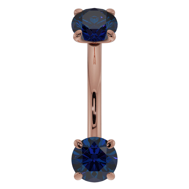 14K rose gold 14G blue sapphire curved barbell, front view with larger round sapphire prong settings