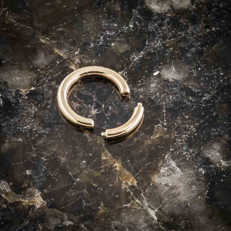 14K yellow gold segment ring open on dark marble surface, showing removable segment detail