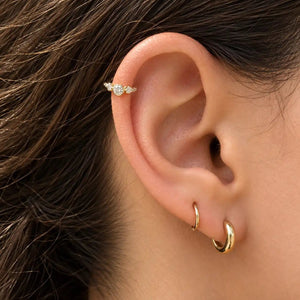 14k gold three-CZ clicker ring worn in helix piercing on model, showing snug fit and sparkle
