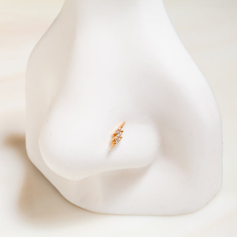 14k yellow gold diamond pavé lightning bolt flat back stud shown on nose piercing display for fit