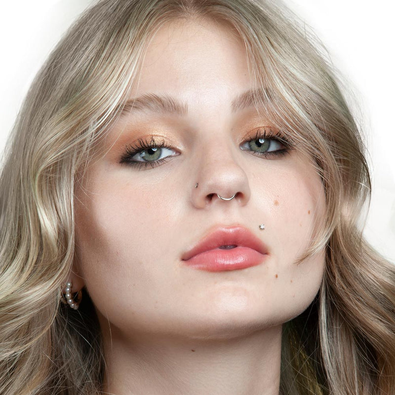 2mm CZ 14k gold flat back labret stud shown in labret piercing below lip on female model, front view