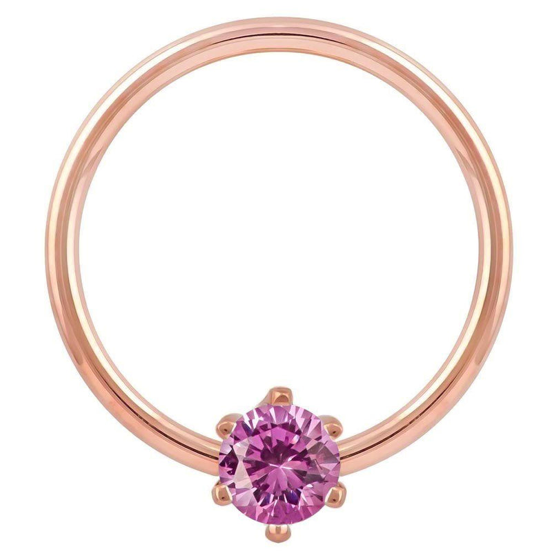 Close-up front view of 14k rose gold captive ring highlighting pink CZ prong setting and band finish