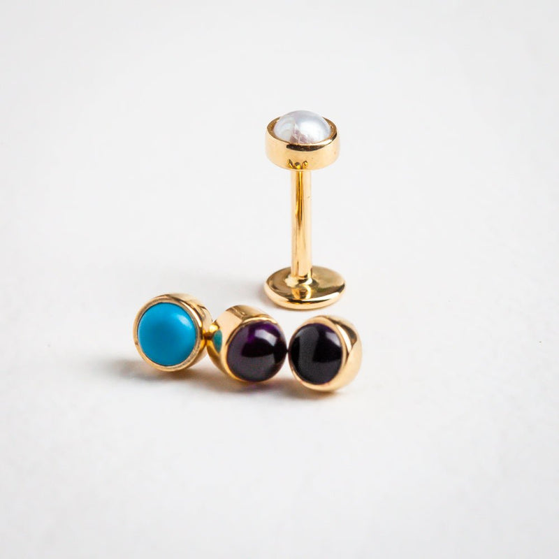 14k gold flat back labret studs in turquoise, amethyst, and black cabochon grouped for comparison