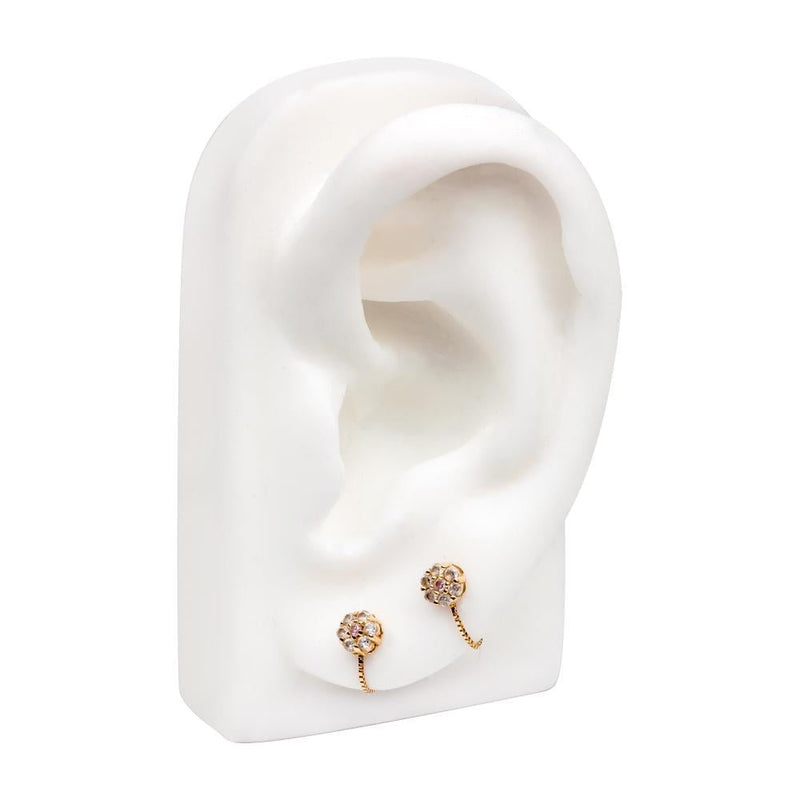 Yellow gold box chain connector on white ear display linking two CZ flower studs in lobe piercings