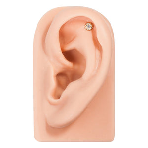 14k gold tiny diamond flower flat back earring shown in helix cartilage piercing on ear model