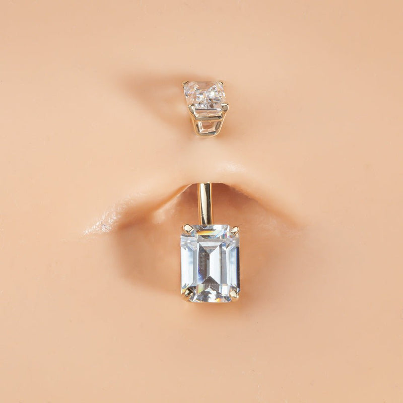 Double emerald-cut clear CZ 14k gold belly ring shown in pierced navel for fit and scale reference