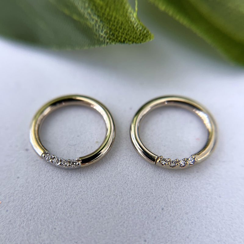 Two 14K yellow gold diamond seam rings side by side on marble surface showing size comparison