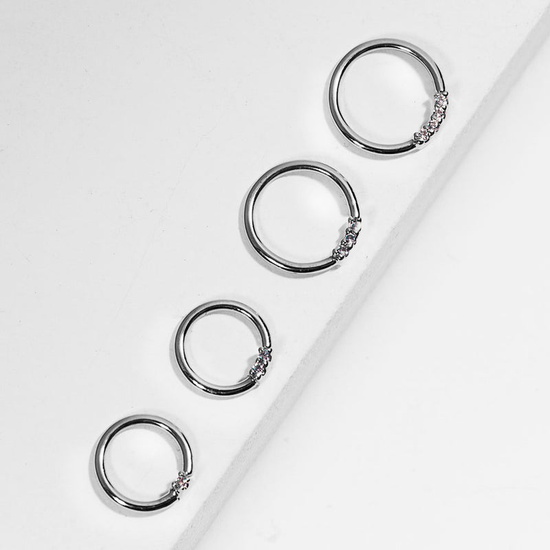 Four 14K white gold diamond seamless hoops in graduating sizes arranged along white ledge