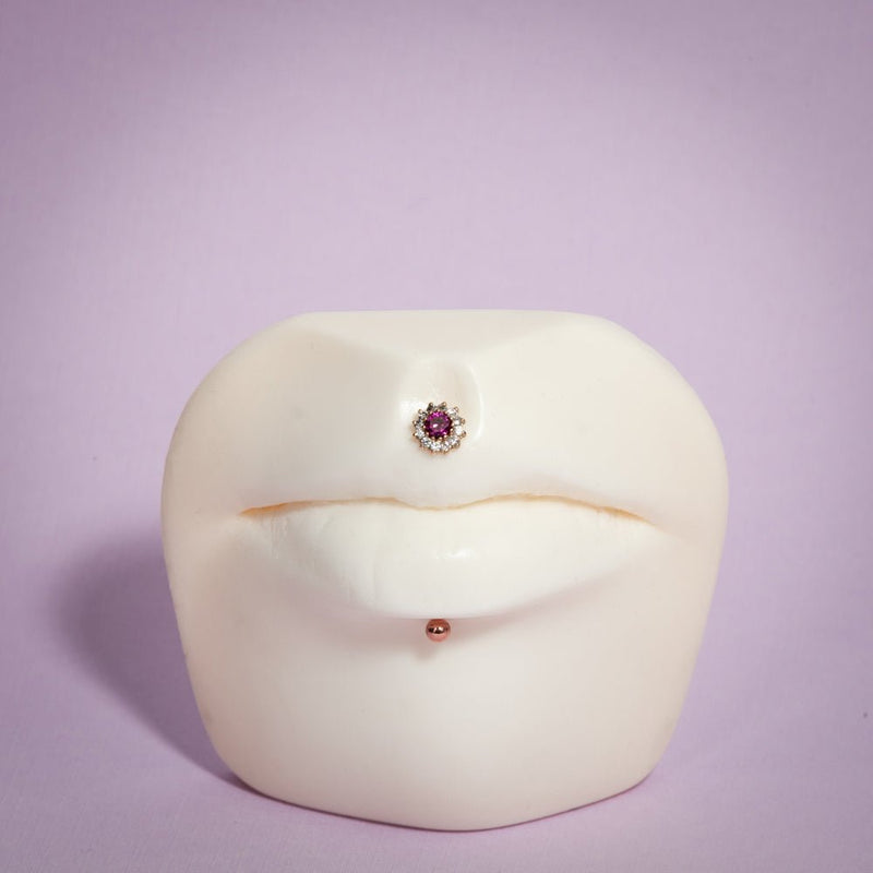 14K rose gold ball labret stud shown in labret piercing below lip on white face display model