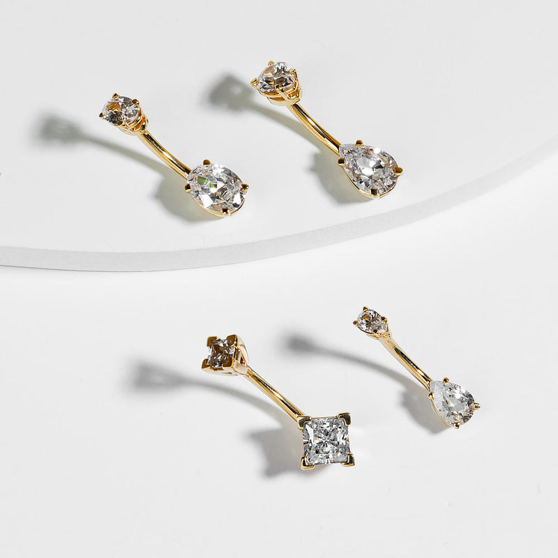 Three 14k gold belly rings with different CZ cuts displayed together for style comparison
