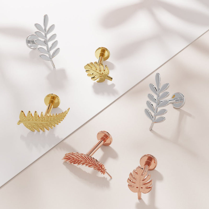 Assorted nature-themed 14K gold flat back earrings including monstera leaf in yellow and rose gold tones