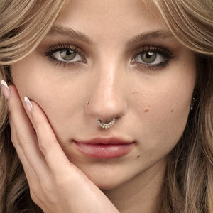 Opal and diamond 14k gold clicker ring hoop worn as a septum piercing on a female model