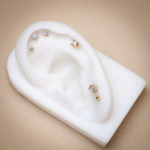 Diamond flat back studs styled on white ear display showing helix and lobe piercing placement