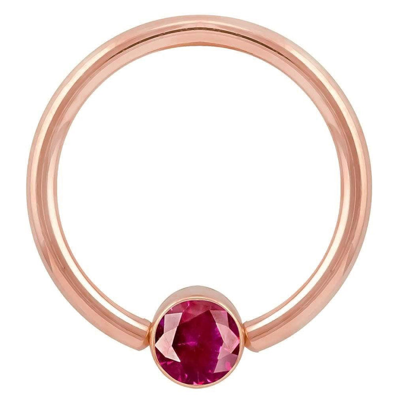 14k rose gold fixed bead ring with red CZ round bezel, angled front view showing warm gold tone