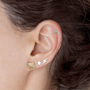 14K gold star stud earring worn in lobe piercing styled with lightning bolt and pyramid studs